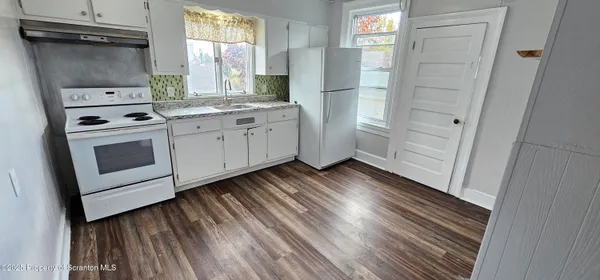 a kitchen with white cabinets and white appliances