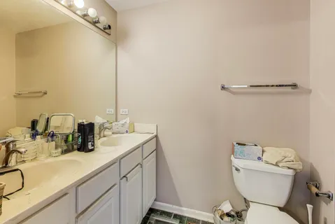 a bathroom with a sink mirror vanity and toilet