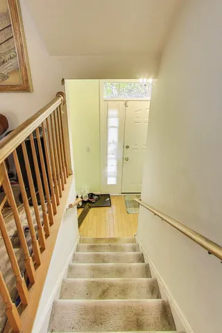 a view of staircase with white walls and a window