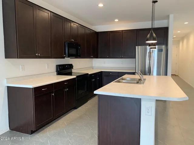 a kitchen with a sink a microwave and cabinets