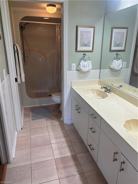 121 Gabriel Circle, Unit 7 Naples, FL 34104 - Photo 15 of 20 Bathroom featuring vanity, toilet, and a shower with shower curtain