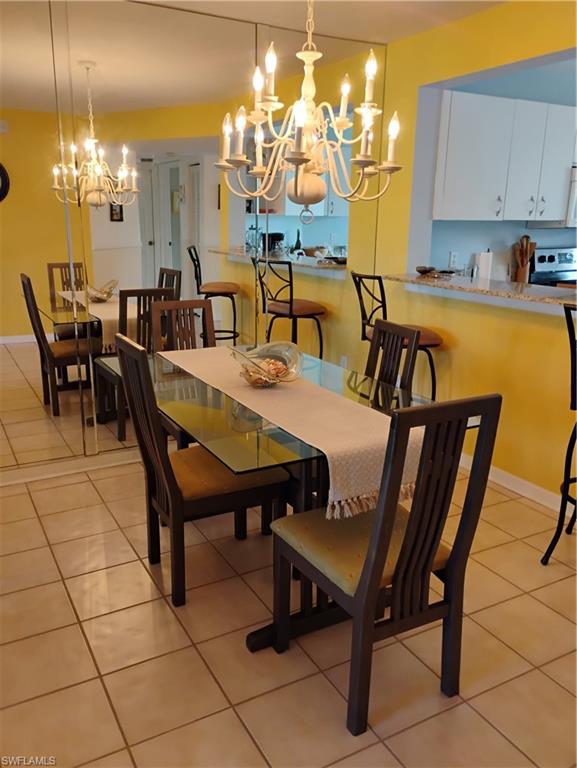 121 Gabriel Circle, Unit 7 Naples, FL 34104 - Photo 8 of 20 Dining space featuring an inviting chandelier and light tile patterned floors