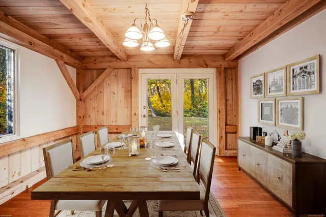 a view of a dining room with furniture a chandelier and wooden floor