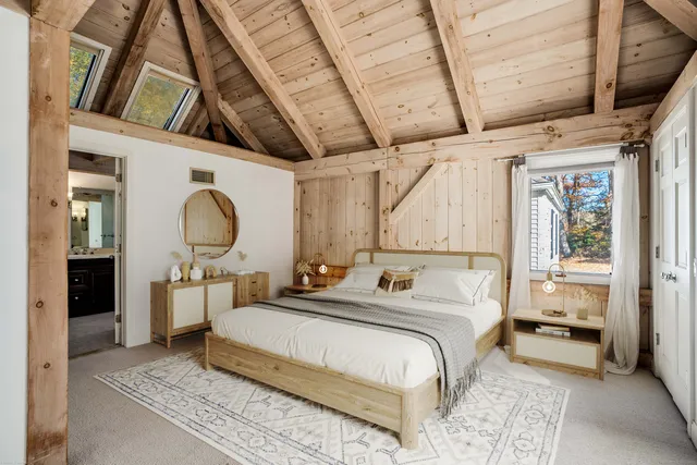 a bed room with a bed mirror and a window