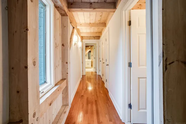 a view of a hallway with wooden floor and staircase