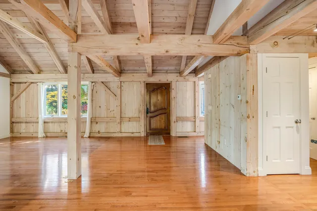 a view of empty room with wooden floor and fireplace