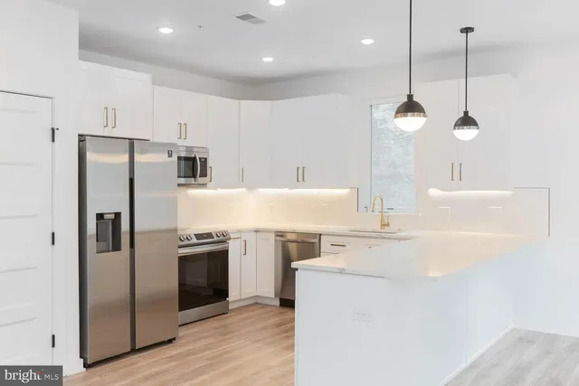 a kitchen with kitchen island a sink stainless steel appliances and cabinets