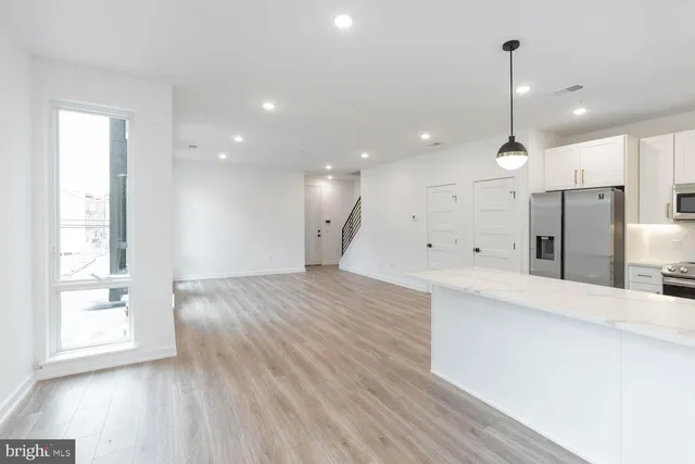a view of a kitchen with a sink and a large window
