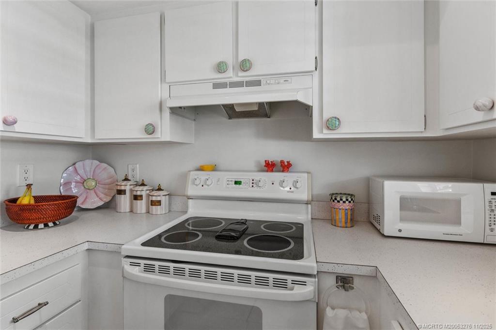2929 Southeast Ocean Boulevard, Unit 1157 Stuart, FL 34996 - Photo 15 of 26 a kitchen with a stove and white cabinets