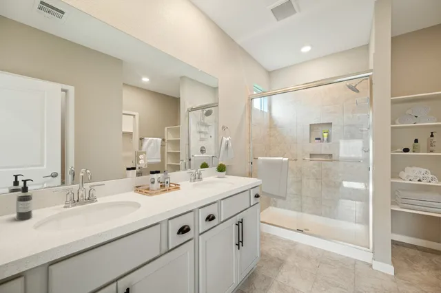 a bathroom with a shower tub double vanity sink and mirror