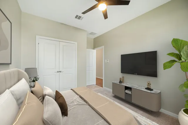 a bedroom with a bed and a flat screen tv on the dresser