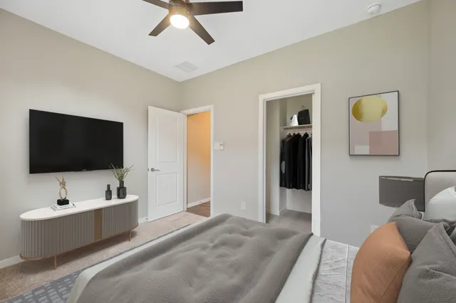 a spacious bedroom with a bed and a flat screen tv