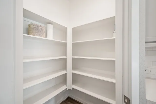 a view of walk in closet with empty racks