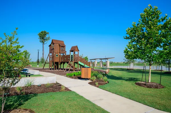 a view of a garden with a house in the background