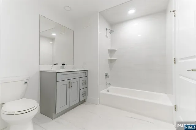 a bathroom with a granite countertop toilet a sink and bathtub