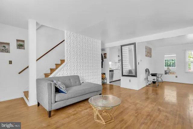 a living room with furniture and a dining table with wooden floor