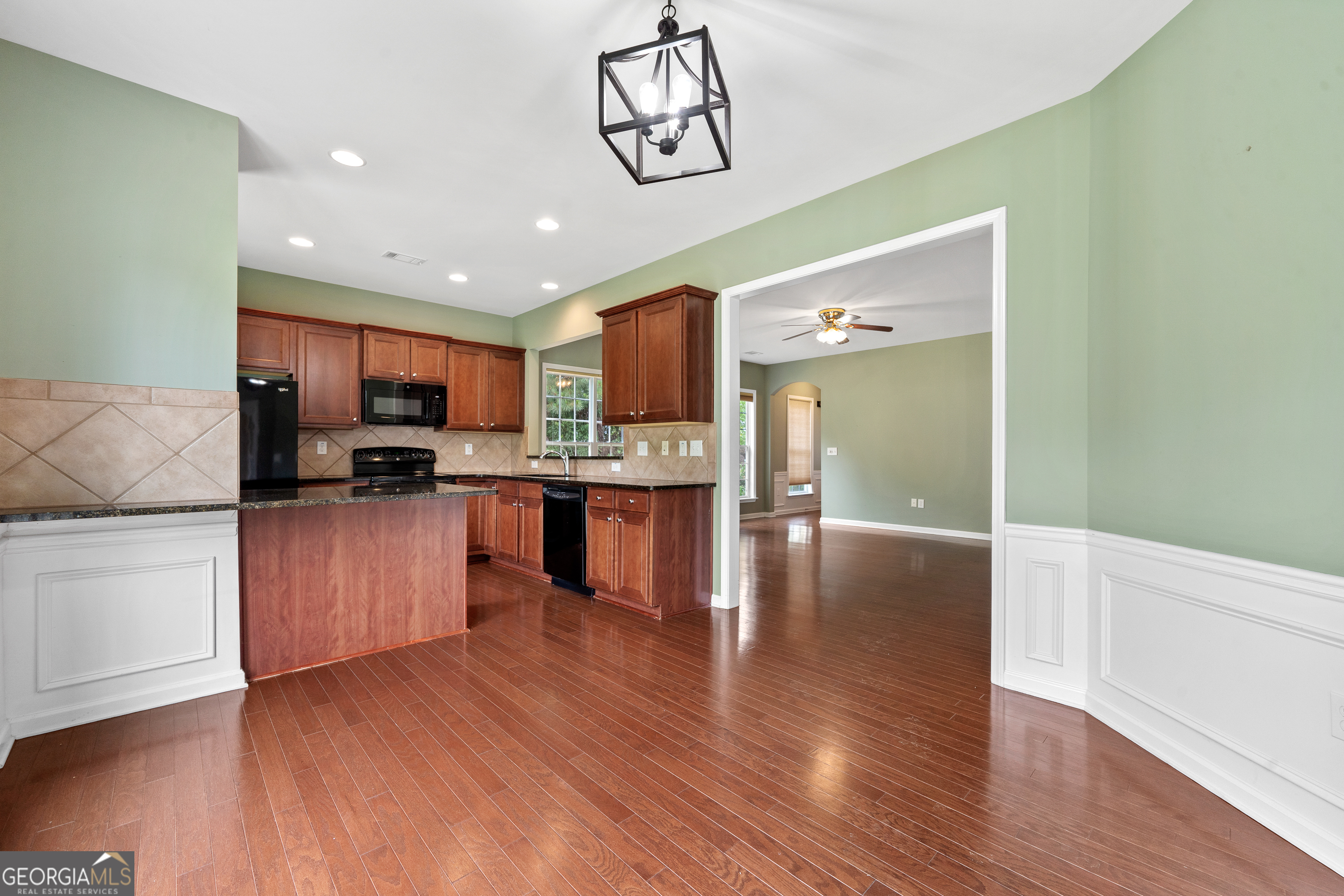 1370 Summer Hollow Road Greensboro, GA 30642 - Photo 13 of 35 a kitchen with stainless steel appliances granite countertop a refrigerator stove top oven and cabinets with wooden floor