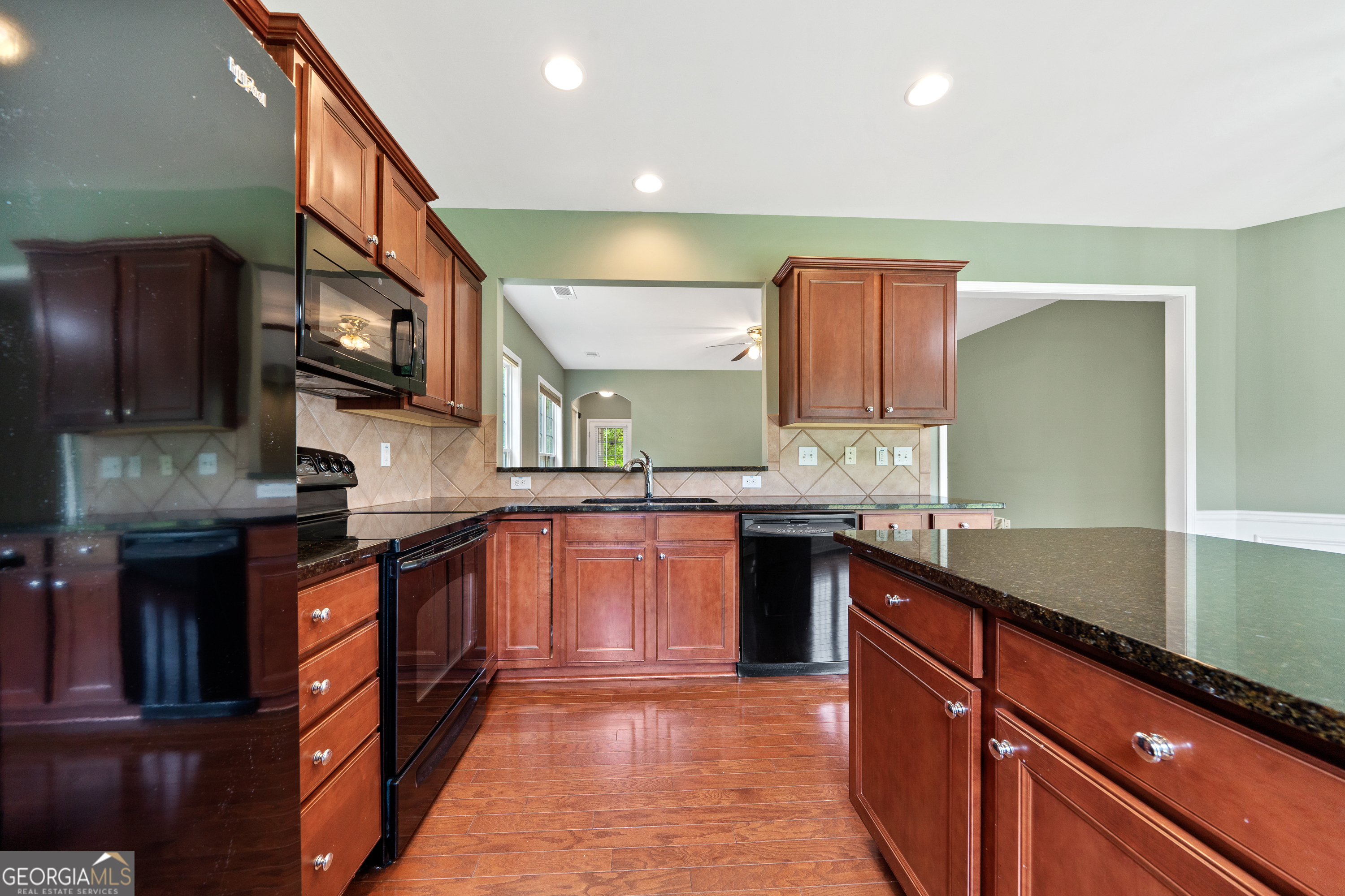 1370 Summer Hollow Road Greensboro, GA 30642 - Photo 18 of 35 a kitchen with stainless steel appliances granite countertop wooden cabinets a stove and a sink