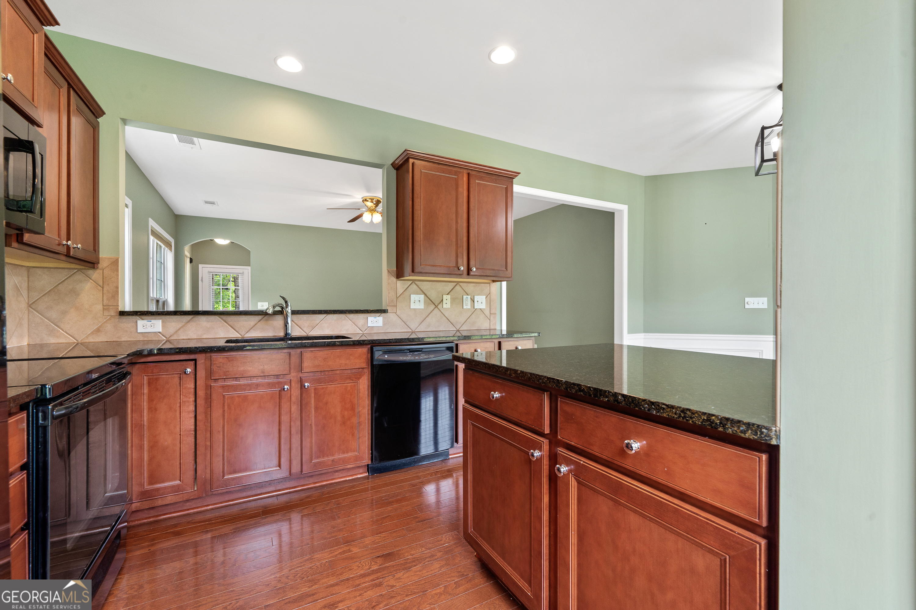 1370 Summer Hollow Road Greensboro, GA 30642 - Photo 19 of 35 a kitchen with granite countertop stainless steel appliances and wooden cabinets