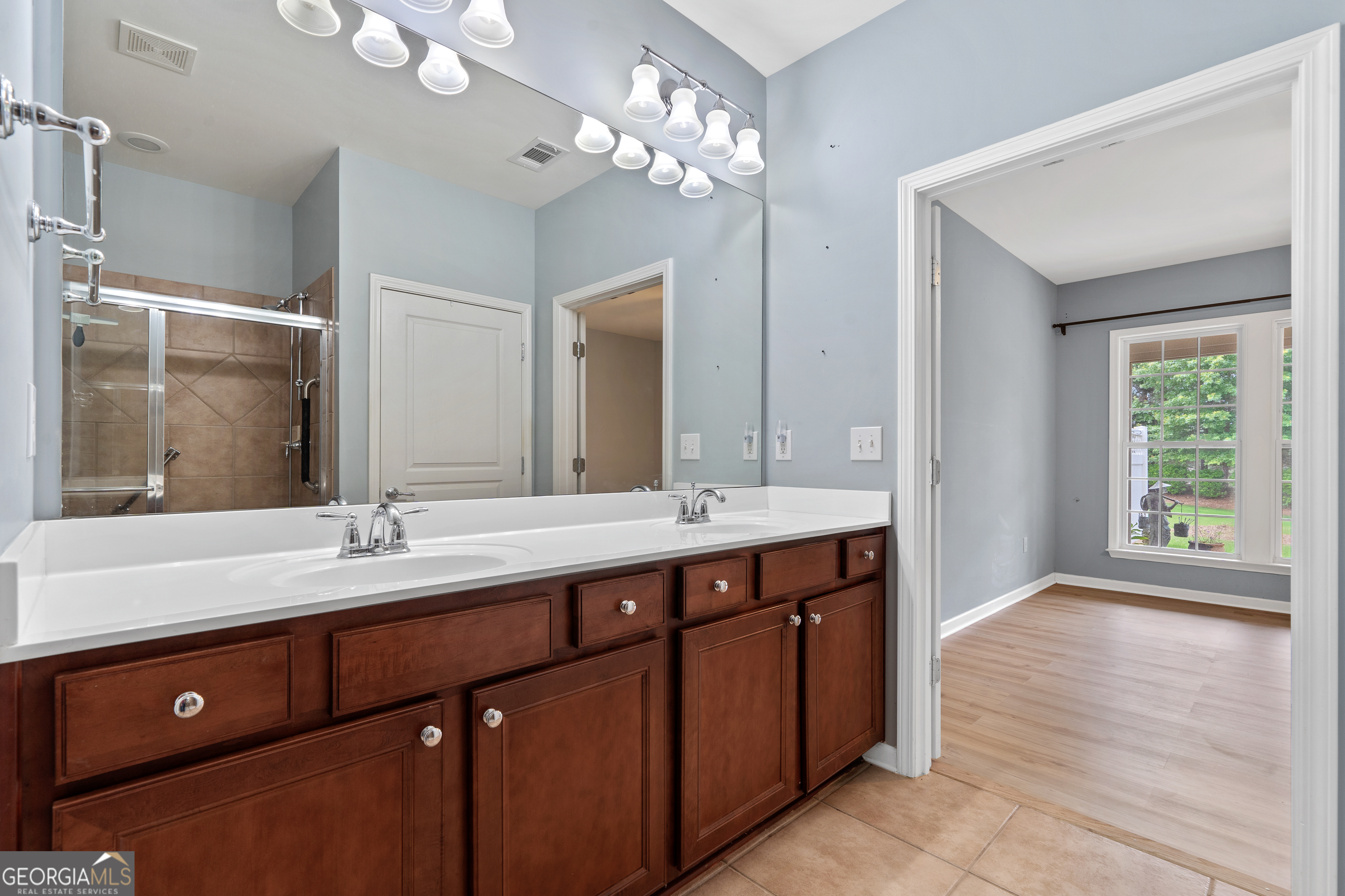 1370 Summer Hollow Road Greensboro, GA 30642 - Photo 25 of 35 a spacious bathroom with a double vanity sink a large mirror and a shower