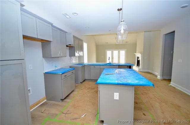 a kitchen with kitchen island a counter top space a sink a refrigerator and window