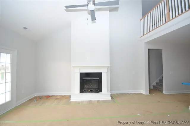 a view of an empty room with a fireplace and a window