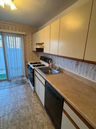 a kitchen with stainless steel appliances a sink a stove cabinets and wooden floor