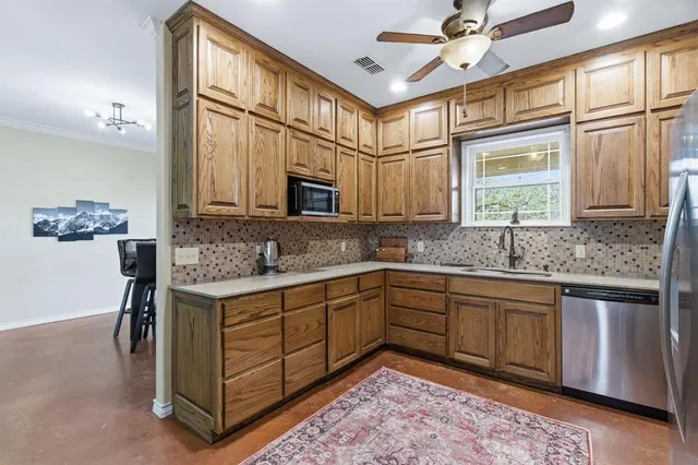 a kitchen with stainless steel appliances granite countertop a sink and a refrigerator