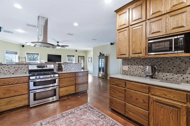 a kitchen with stainless steel appliances granite countertop a stove and cabinets