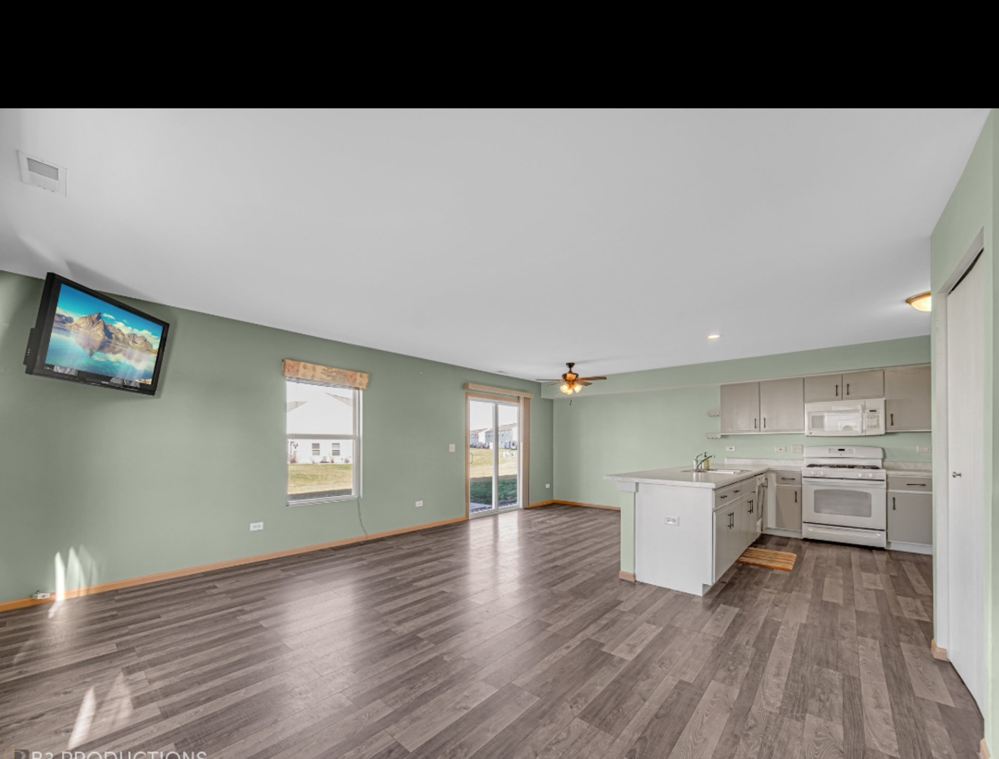 25288 Faraday Road Manhattan, IL 60442 - Photo 8 of 17 a living room with stainless steel appliances kitchen island hardwood floor and a window