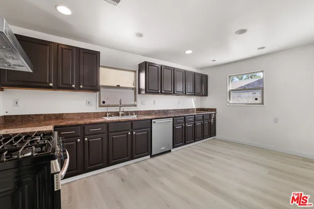 a kitchen with stainless steel appliances granite countertop a stove a sink dishwasher and a refrigerator