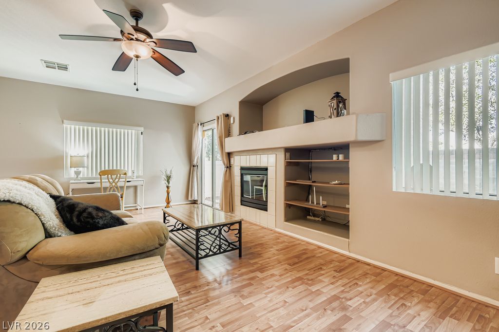 1586 Rusty Ridge Lane Henderson, NV 89002 - Photo 2 of 11 A cozy living space boasts a built-in fireplace and warm hardwood floors.