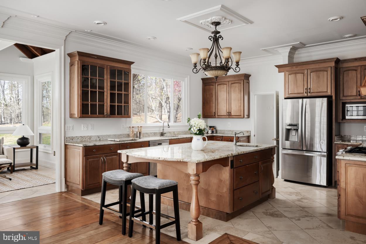 5930 Wilson Road Marshall, VA 20115 - Photo 14 of 46 a kitchen with stainless steel appliances granite countertop a stove top oven a refrigerator a sink dishwasher a dining table and chairs with wooden floor