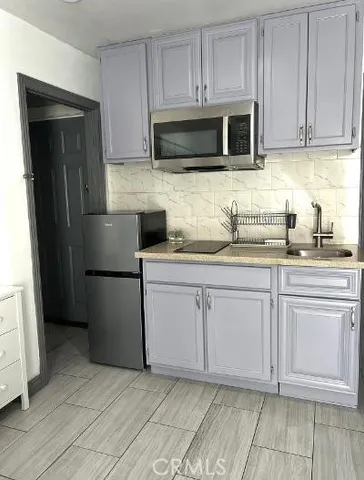 a kitchen with stainless steel appliances granite countertop a refrigerator stove top oven and sink