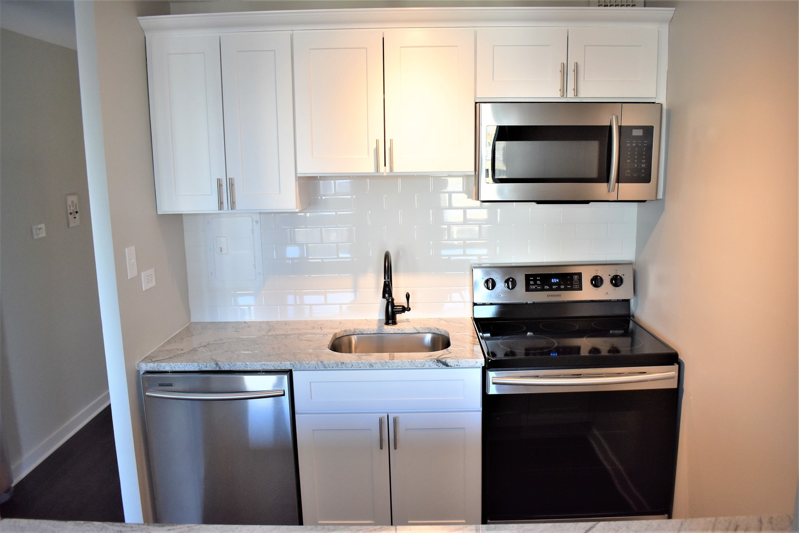 6166 North Sheridan Road, Unit 10D Chicago, IL 60660 - Photo 3 of 23 a kitchen with a microwave a stove and a sink
