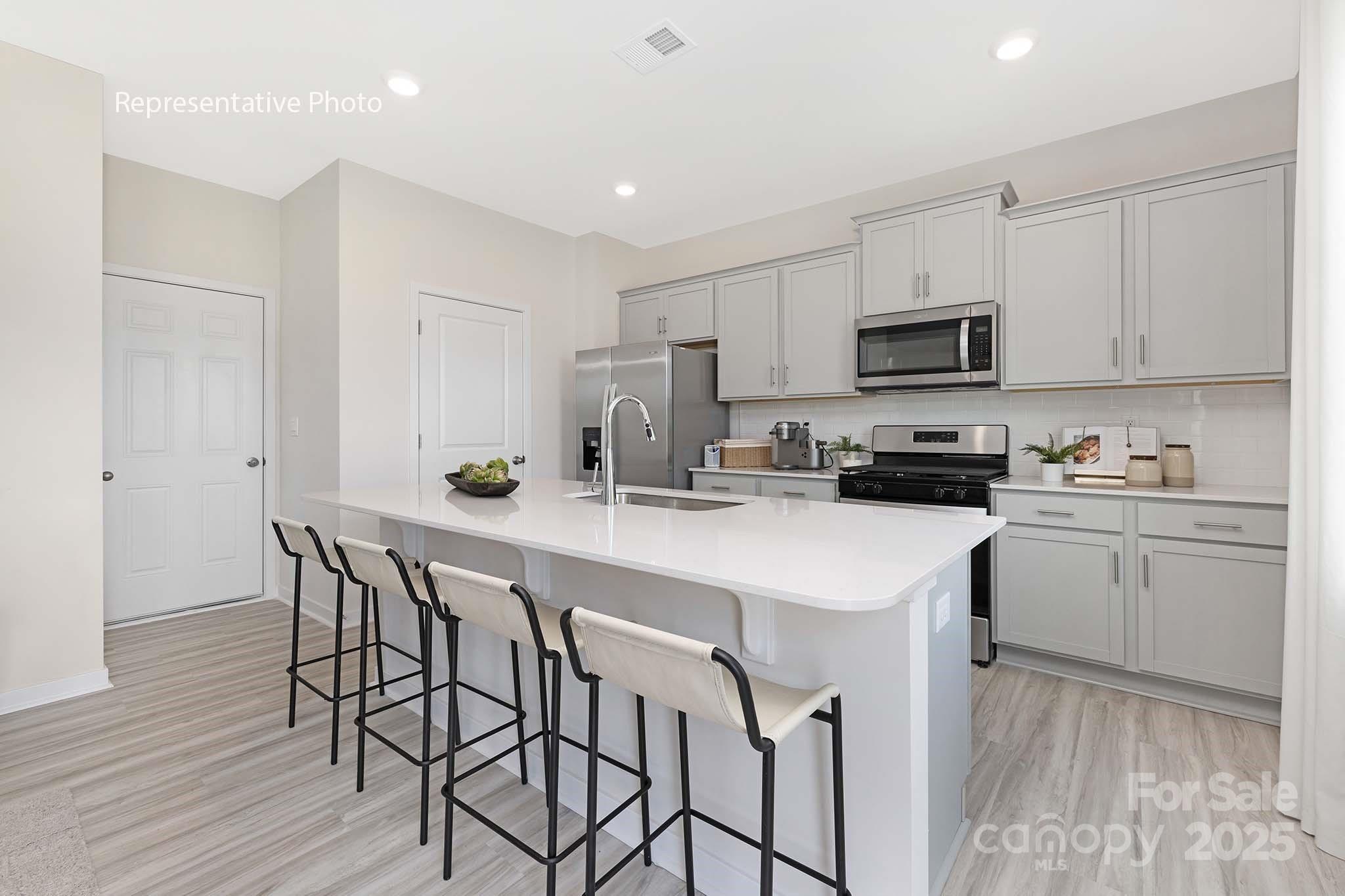 2683 Goose Fair Road Maiden, NC 28650 - Photo 6 of 22 a kitchen with stainless steel appliances a white table chairs refrigerator microwave and cabinets