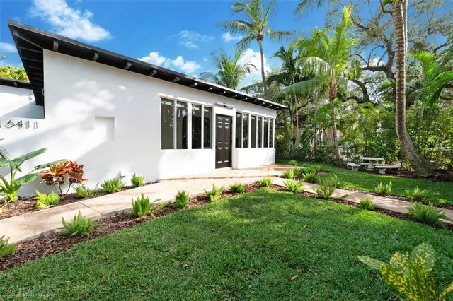 a view of a house with backyard and sitting area