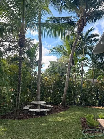 a couple of palm trees sitting in a yard with swimming pool