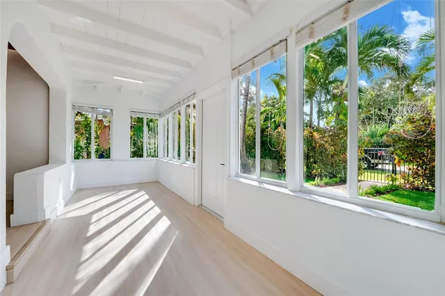 a view of a bedroom with large windows and wooden floor