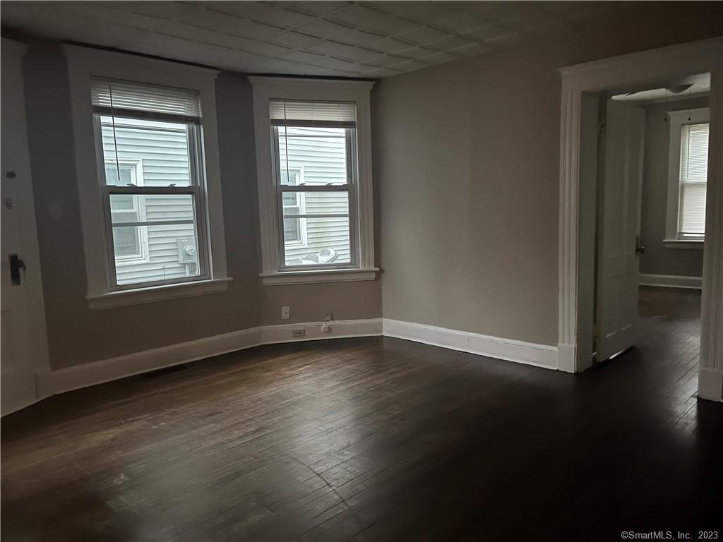 253 North Main Street, Unit 1 Naugatuck, CT 06770 - Photo 8 of 11 an empty room with wooden floor and windows