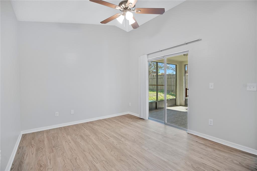 1537 Rivers Edge Drive Orlando, FL 32825 - Photo 17 of 30 an empty room with wooden floor chandelier fan and windows