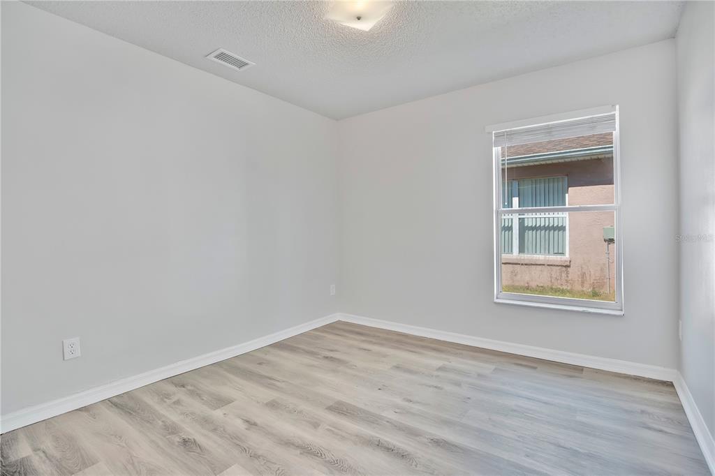 1537 Rivers Edge Drive Orlando, FL 32825 - Photo 18 of 30 a view of an empty room with wooden floor and a window