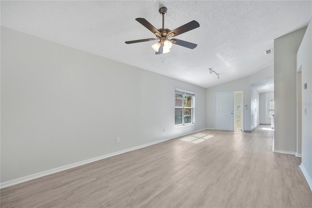 1537 Rivers Edge Drive Orlando, FL 32825 - Photo 5 of 30 an empty room with wooden floor fan and windows