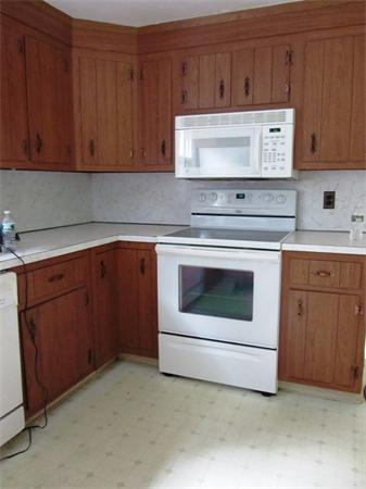18 Constitution Road Lexington, MA 02421 - Photo 5 of 11 a stove top oven sitting inside of a kitchen with granite countertop wooden cabinets