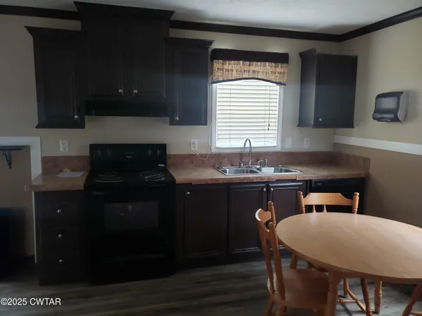 a kitchen with a sink cabinets and wooden floor