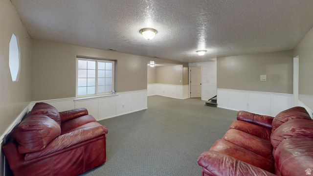 9029 North Treasureton Road Preston, ID 83263 - Photo 14 of 31 Living room featuring wainscoting, a textured ceiling, and carpet floors