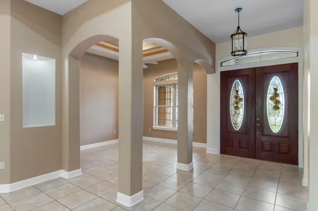 a view of a livingroom with a large window and chandelier fan