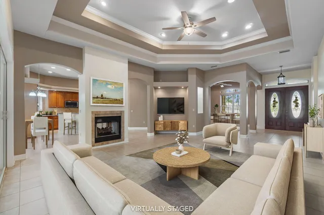 an empty room with a fireplace and chandelier fan