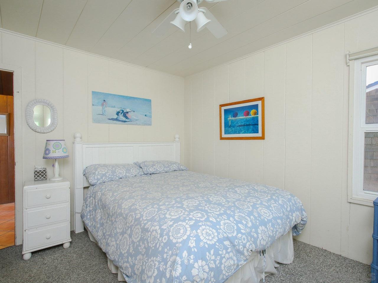 2212 Ocean Front Del Mar, CA 92014 - Photo 10 of 17 a bedroom with a bed and a chandelier