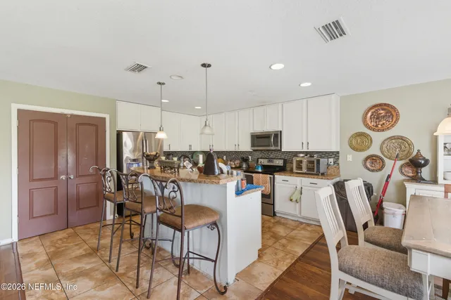 a dining room with furniture a chandelier and wooden floor